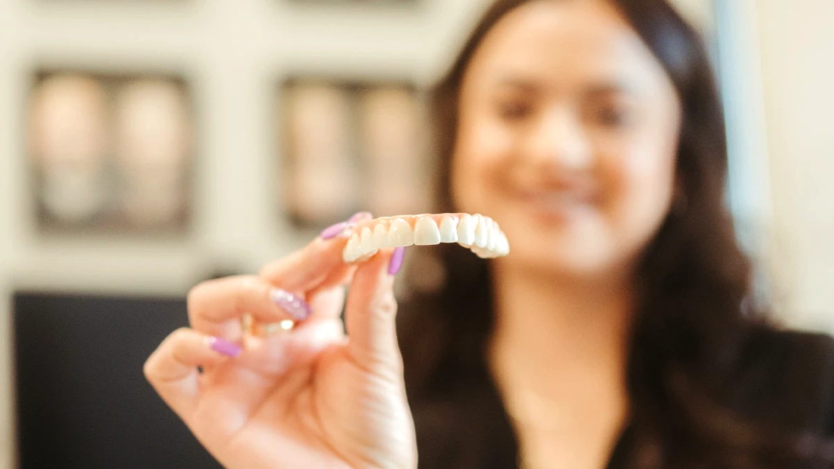 A person holding a clean all on 4 upper bridge - how to clean All-On-4 dental implants